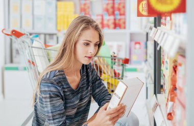 Young woman doing grocery shopping clipart