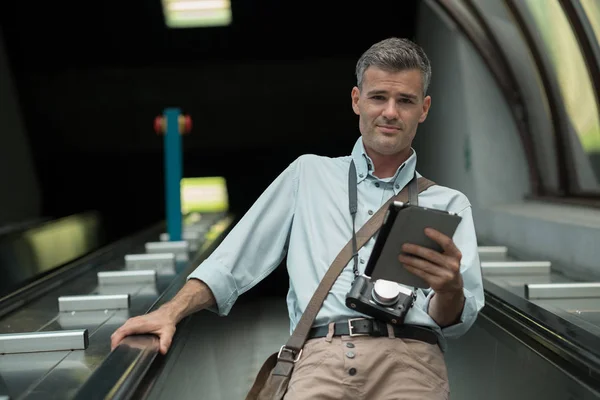 Tourist on escalator with tablet — Stock Photo, Image