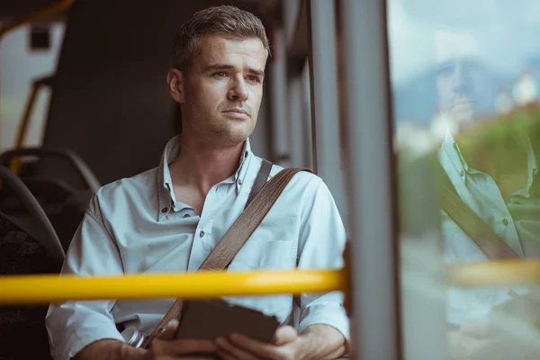 Självsäker fundersam man som sitter i bussen — Stockfoto