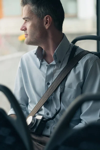 Male tourist with camera riding bus — Stock Photo, Image