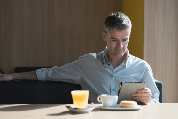Geschäftsmann sitzt mit Tablet — Stockfoto
