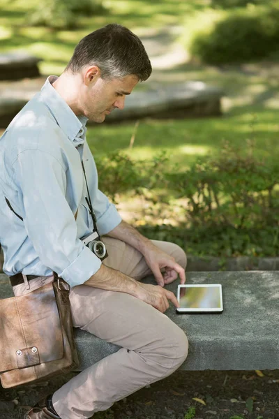 Muž v parku pomocí tabletu — Stock fotografie