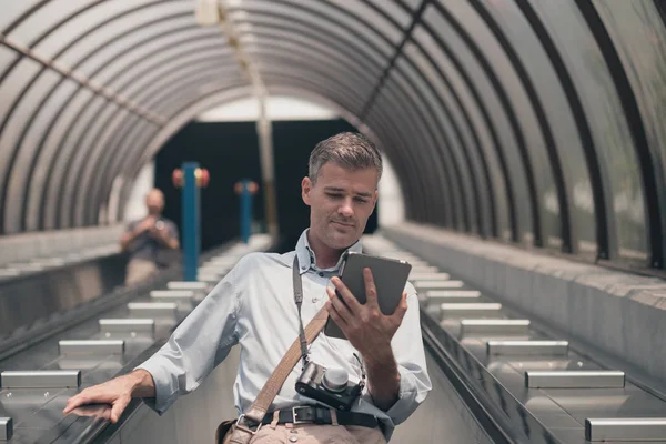Muž s tabletem na eskalátoru — Stock fotografie
