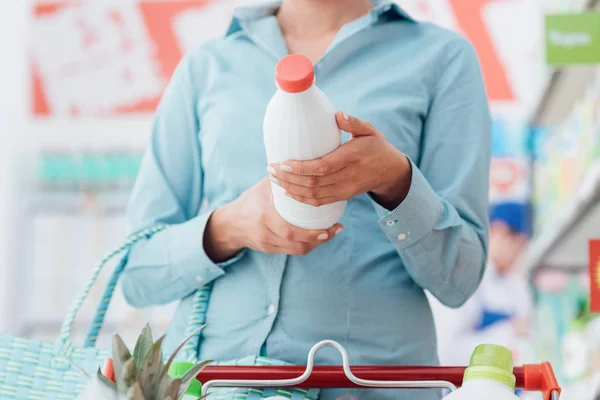 Mulher lendo rótulos de alimentos — Fotografia de Stock