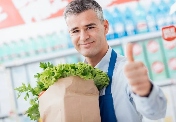Assistente de loja segurando saco de supermercado — Fotografia de Stock
