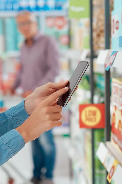 Donna shopping e utilizzando smartphone — Foto Stock