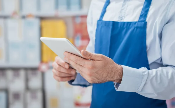 Supermercado clerk usando aplicativos em tablet — Fotografia de Stock