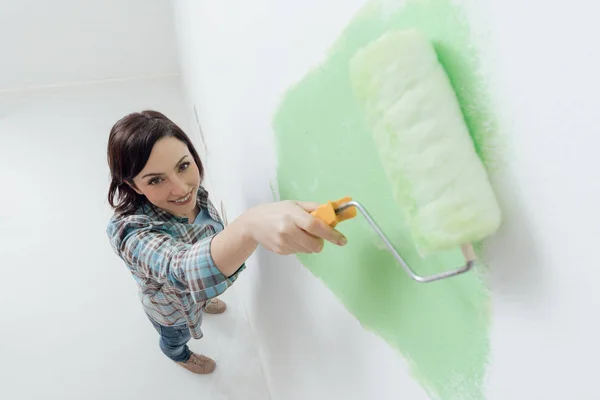 Lachende vrouw schilderij kamer — Stockfoto