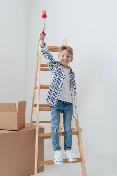 Schattige jonge jongen staande op een ladder — Stockfoto