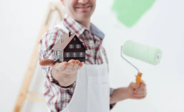 Painter holding model of house — Stock Photo, Image
