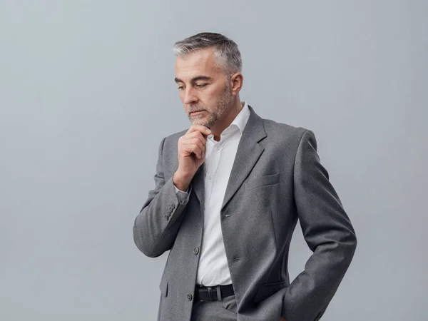 Hombre de negocios pensativo con la mano en la barbilla — Foto de Stock