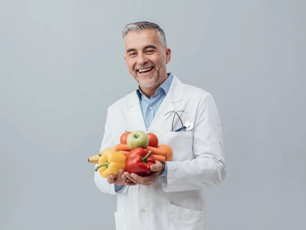 Nutricionista segurando legumes frescos e frutas — Fotografia de Stock