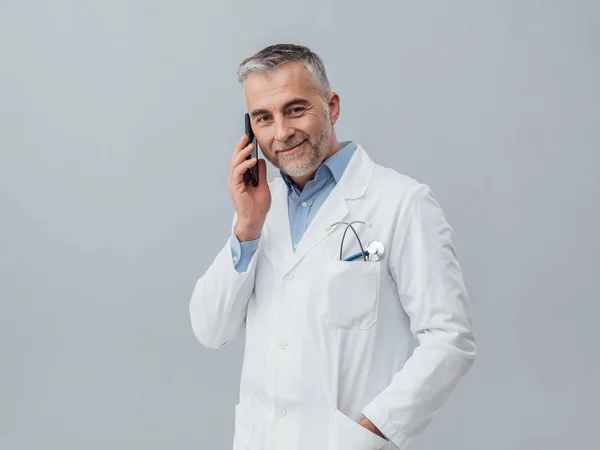 Médico maduro confiante ter telefonema — Fotografia de Stock