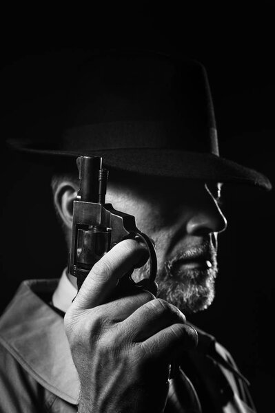 Detective holding gun in dark