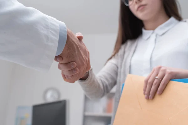 Médico estrechando las manos con el paciente femenino —  Fotos de Stock