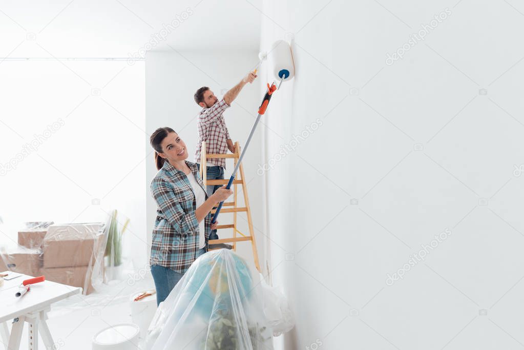  happy couple painting new house 