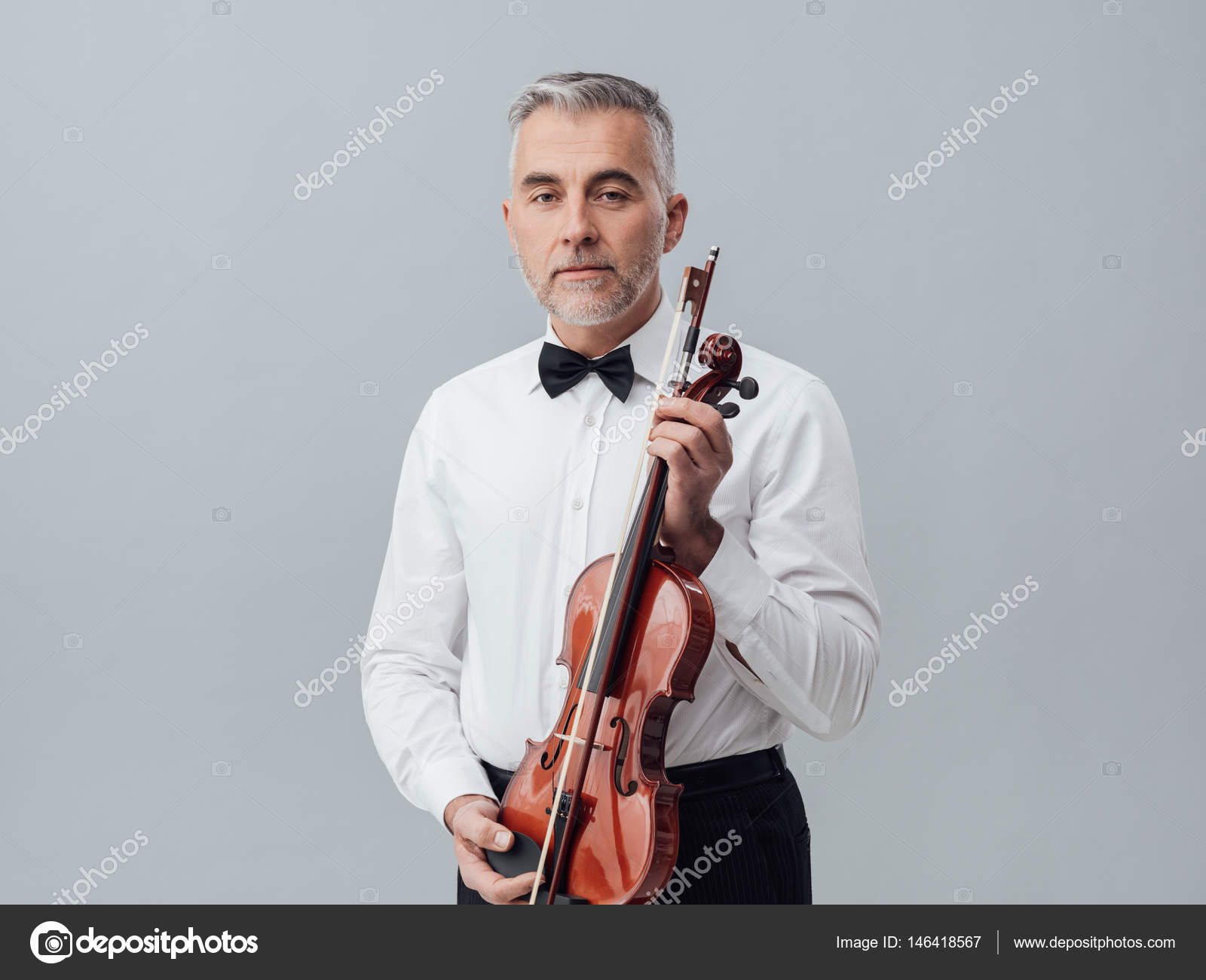 ヴァイオリンでポーズをとって自信を持って成熟した音楽家 ストック写真 C Stokkete