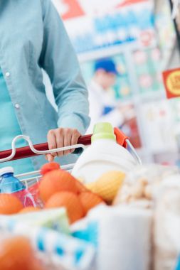 Süpermarkette alışveriş sepeti iterek kadın