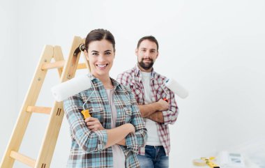 Çift gülümseyen ve boya merdaneleri holding