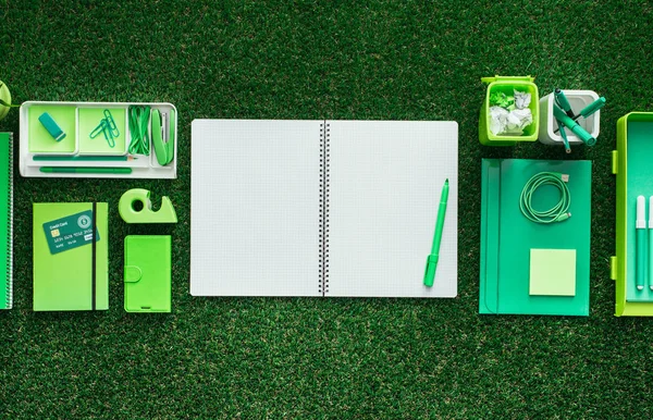 Notebook com artigos de papelaria na área de trabalho grama — Fotografia de Stock