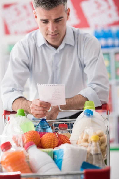Homme faisant du shopping avec liste d'épicerie — Photo