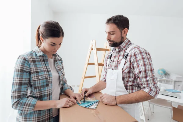 Decorador mostrando amostras de cor para a mulher — Fotografia de Stock