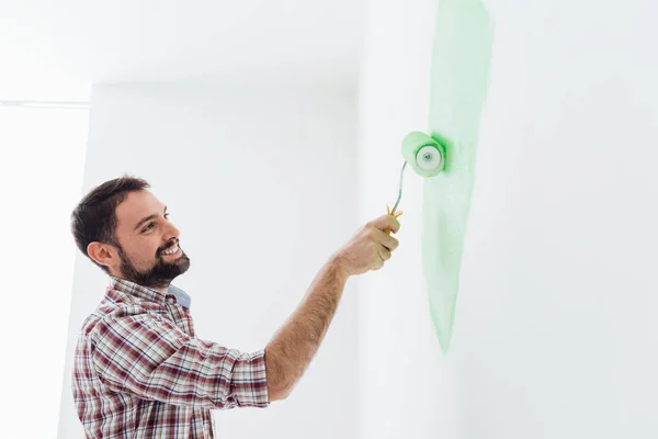 Smiling man painting walls in apartment — Stock Photo, Image