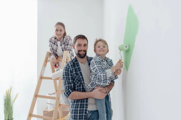 Pai segurando filho com rolo de pintura — Fotografia de Stock