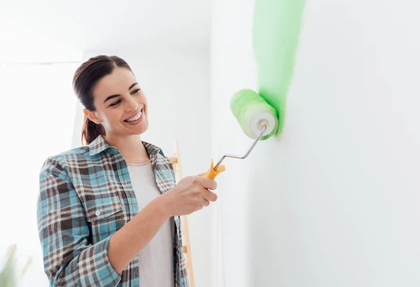 Woman applying green paint to walls — Stock Photo, Image