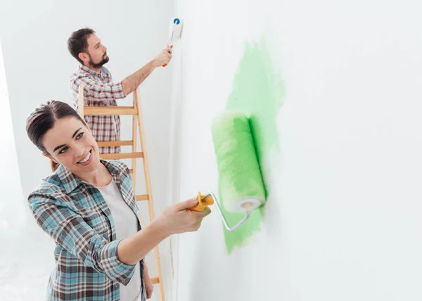 Щаслива пара малює стіни в будинку — стокове фото