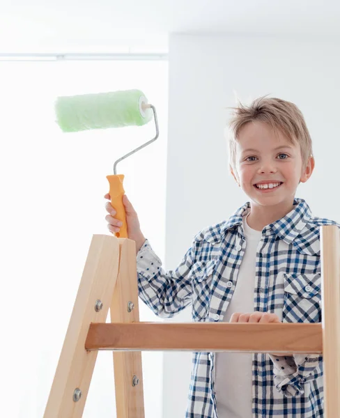 Boy standing on ladder with paint roller — Stock Photo, Image