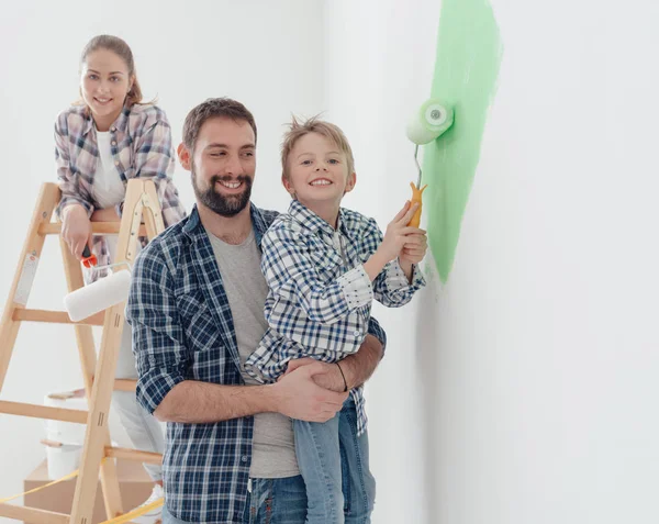 Father holding son with paint roller — Stock Photo, Image