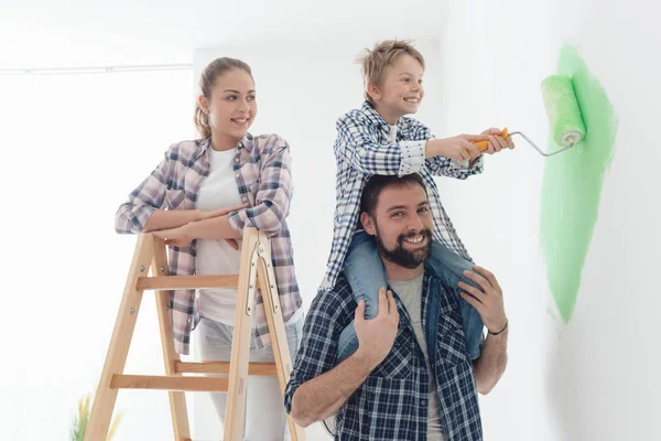Father piggybacking son with paint roller — Stock Photo, Image