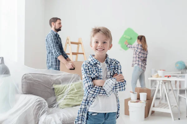 Мальчик улыбается, пока мама рисовала комнату — стоковое фото
