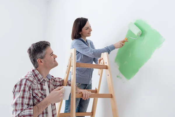 Kvinna målning vägg av paint roller — Stockfoto
