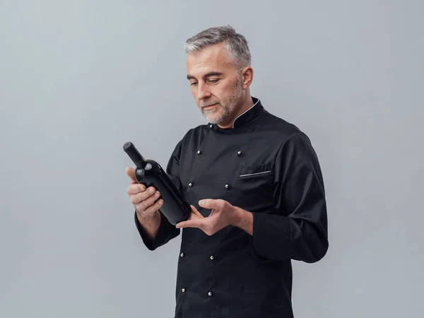 Profi-Koch hält Flasche Wein in der Hand — Stockfoto