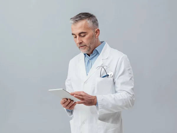 Selbstbewusster Arzt mit digitalem Tablet — Stockfoto