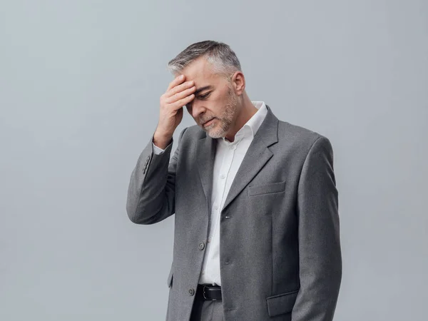 Erschöpfter Geschäftsmann berührt Stirn — Stockfoto