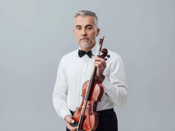 Självsäker mogen musiker poserar med violin — Stockfoto