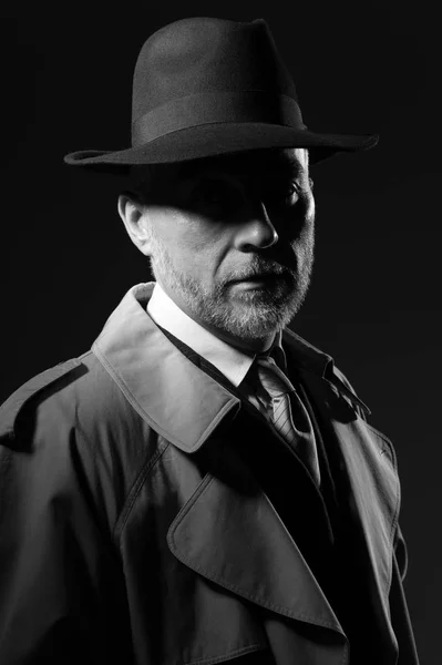 Hombre posando en la oscuridad con sombrero y abrigo —  Fotos de Stock