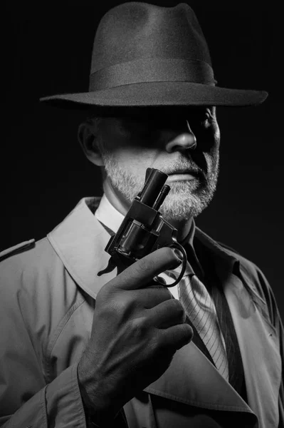 Homem segurando arma no escuro — Fotografia de Stock