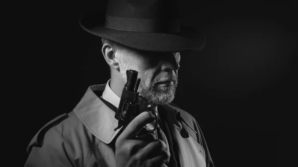 Detective segurando arma no escuro — Fotografia de Stock