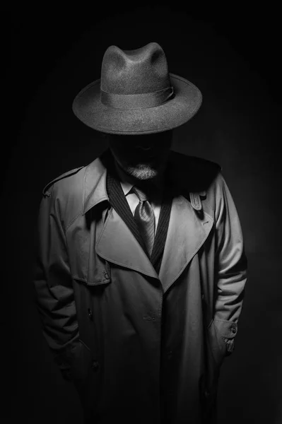 Mannen som poserar i mörkret med hatt och kappa — Stockfoto
