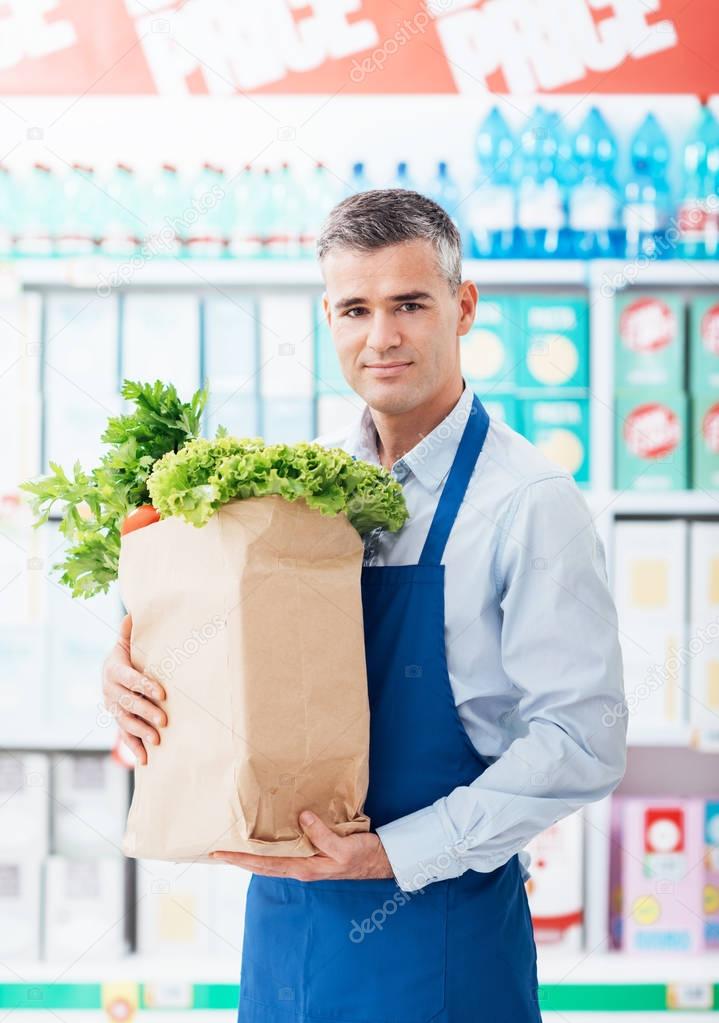 supermarket clerk holding grocery bag
