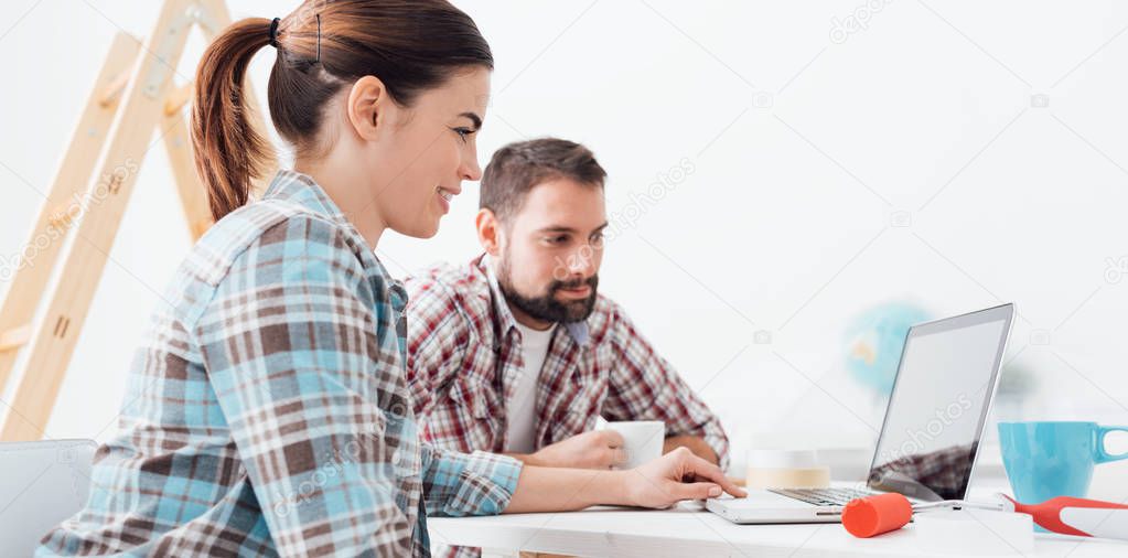 Young smiling couple using laptop