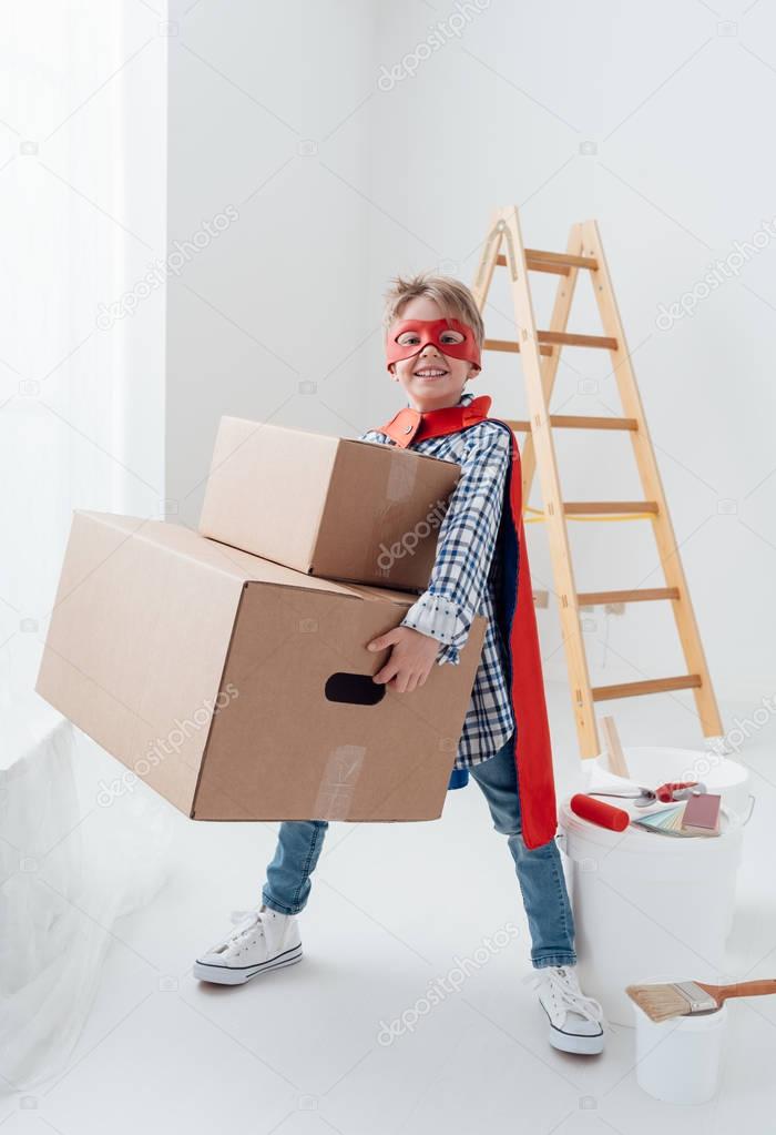superhero boy carrying heavy boxes