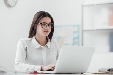 Dizüstü bilgisayarda yazan genç kadın.