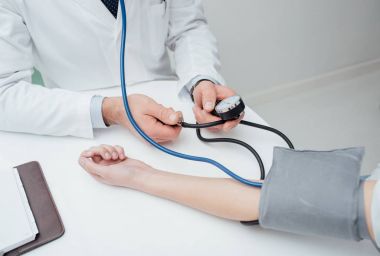 Doktor hastanın kan basıncını kontrol