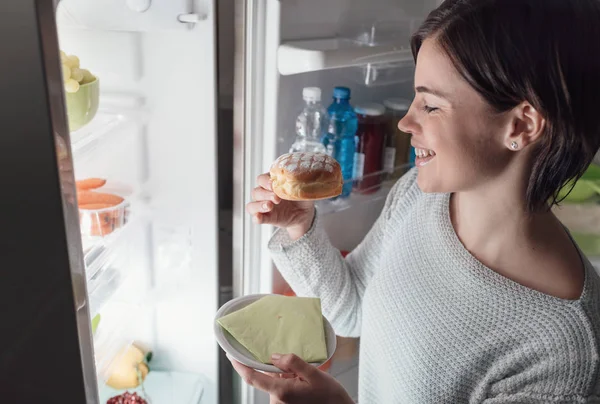 Wanita mengambil makanan ringan dari lemari es — Stok Foto
