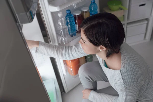 Femme sortant de la nourriture du frigo — Photo